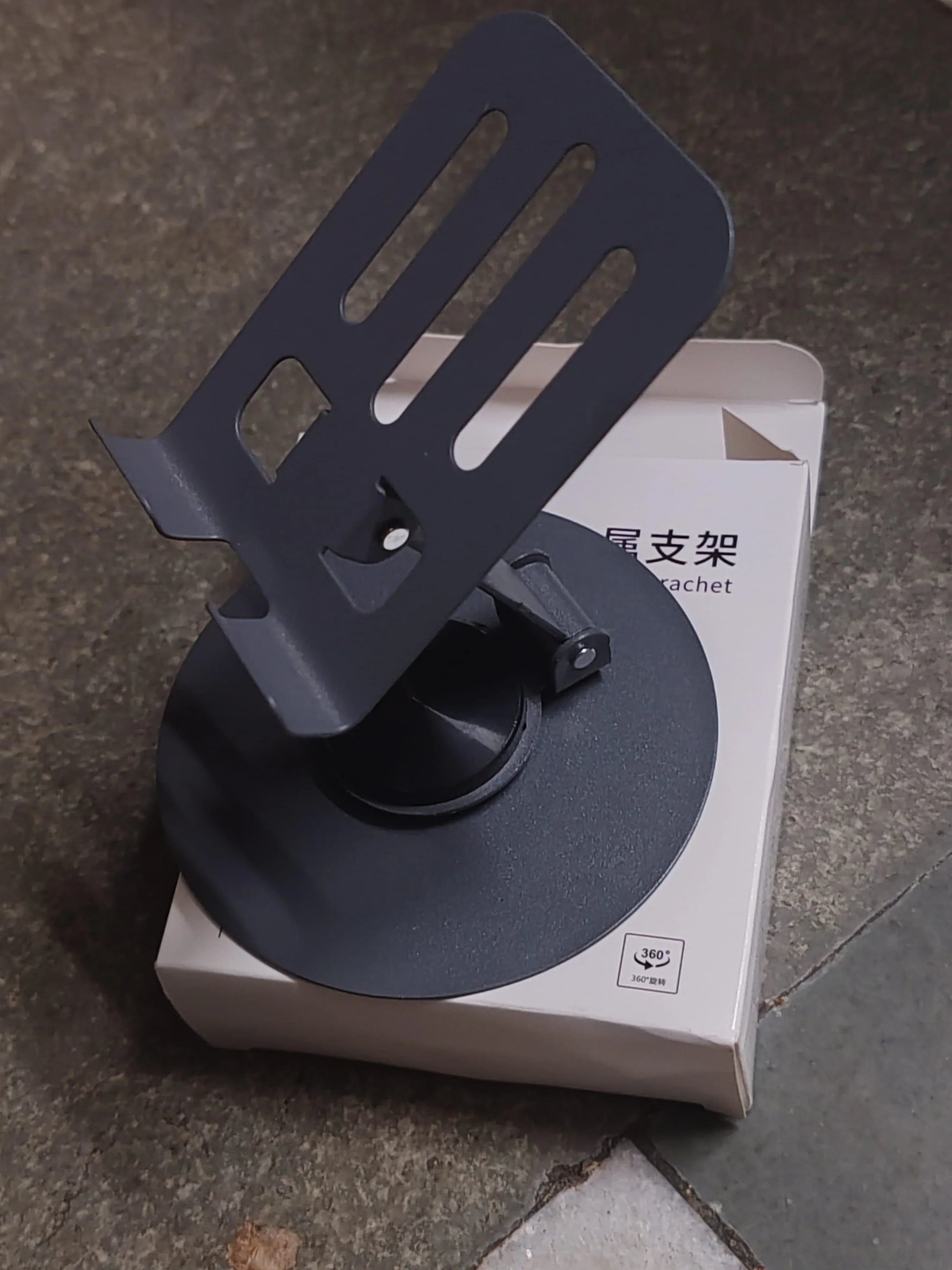 Black adjustable mobile stand for desk with ventilation slots and stable base on packaging