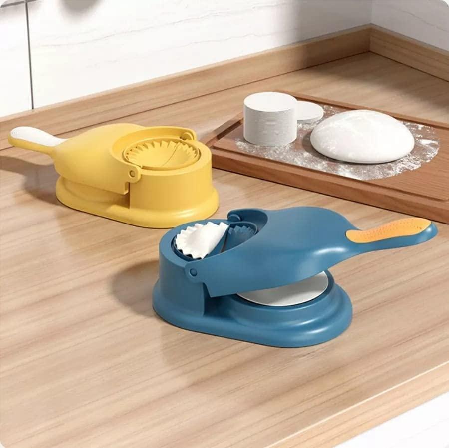Blue and yellow handheld plastic momos gujiya maker set on wooden countertop with dough and flour board