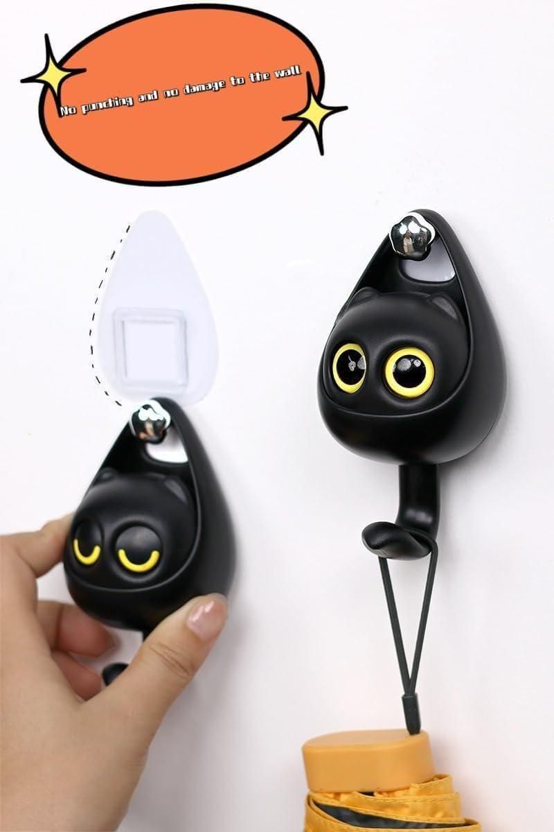 Black cat shaped adhesive key holders with yellow eyes holding a bag strap cute wall key hooks for entryway organization